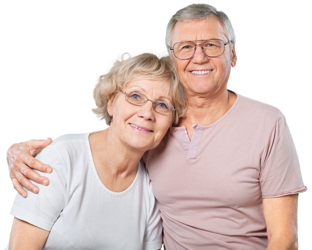 Relationship Therapy can be life changing. An elderly couple, both wearing glasses, smile warmly at the camera. The woman has short blond hair and wears a white shirt, while the man has short gray hair and wears a light pink shirt. The man has his arm around the woman.